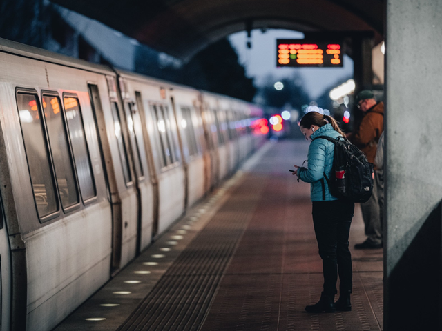 Two passengers waiting on the platform at a MD Metro station